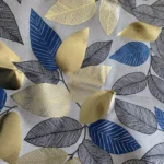 Toile de Coton Feuilles métallisés dorées et bleu sur fond Ecru